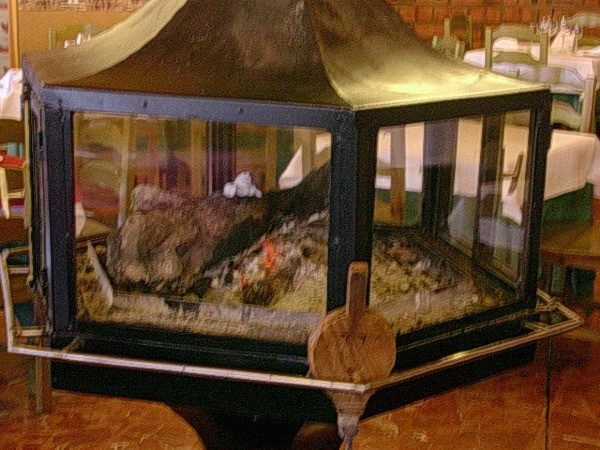 La chimenea de hierro y cristal en el centro del comedor